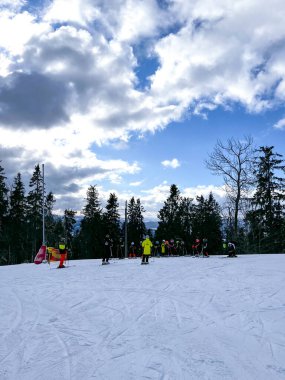 Bukovel Ukraine - February 2022 Children Skier learning skiing downhill in winter resort mountains. Ski area. Skiers and snowboarders riding down the hill. Skiers and lifts in Carpathians alpine ski