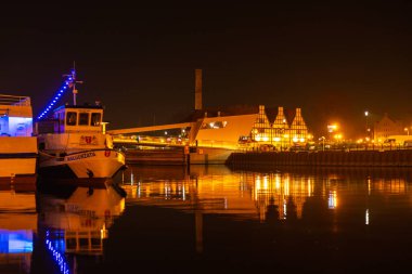 Gdansk Poland - May 2022 Old town in Gdansk at night. The riverside on Granary Island reflection in Moltawa River Cityscape at twilight. Ancient crane at dusk. Visit Gdansk Poland Travel destination
