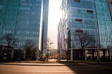 Sun goes through city skyscraper public transport scene in Gdansk. Oliva business district Transport city traffic. Trams buses cars City Traffic Jam. City life