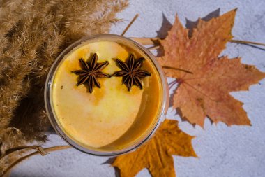 Balkabaklı, baharatlı latte. Anason yıldızları. Baharatlı balkabağı aromalı sonbahar kahvesi mevsimlik sıcak içecek. Cadılar Bayramı ve Şükran Günü için sonbahar içkileri. Vejetaryen sağlıklı diyet yemekleri