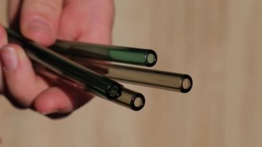 Renkli arka planda yeniden kullanılabilir cam pipetler tutan kadın temizlik fırçası ile çevre dostu içme saman seti yeniden kullanılabilir konforlu yuvarlak uçlu pipet içiyor. Sıfır atık, plastiksiz konsept