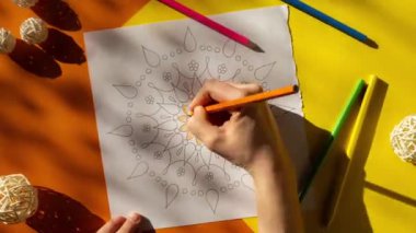4k Timelapse Woman coloring antistress page. Female hand painting mandala. Female painting mandalas to combat stress. Relaxing hobby mental wellbeing and art therapy. Woman paints sketch, meditative