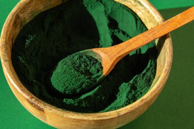 Blue-green algae Chlorella and spirulina powder in bamboo eco bowl, dietary supplement for Vegan, Vegetarian or Plant based diet multivitamins B12, Super powder in spoon. Food supplement source of
