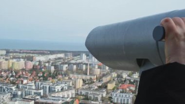 Using tourist binoculars look the old city from the roof top in Gdansk. Oliva star business district Transport city traffic. Trams buses cars City Traffic Jam City life