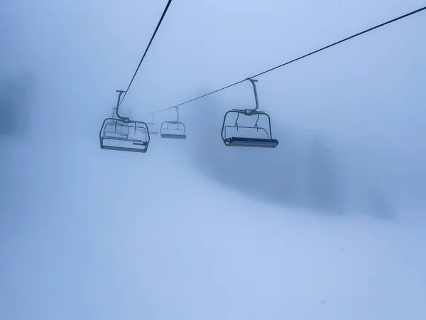 Ski Lift snowy mountain winter forest with chair lift At The Ski Resort in winter. Snowy weather Ski holidays Winter sport and outdoor activities Outdoor tourism skiing snowboarding