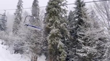 POV Boş Kayak Kaldırma Dağlık Kış Ormanı ve kışın Kayak Tatil Köyü 'nde sandalye kaldırma. Kar yağışlı hava Tatilleri Kış sporları ve açık hava aktiviteleri Snowboard sporu