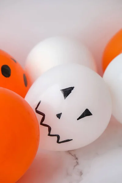 Painted Jacks face on balloons. Orange and white balls preparation diy for halloween party. Halloween home activities. Handmade toys Children craft