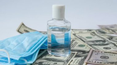 4k zoom in out Stack of cash dollars and medical mask sanitizer antiseptic. The concept of medical expensive medicine Health Life insurance. vaccination costs. Covid-19 crimes. Financial crisis
