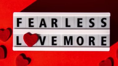 4k zoom in out Lightbox with text FEAR LESS LOVE MORE. Motivational Words Quotes Concept with red hearts. Colorful red background. Minimalistic creative concept. Inspirational phrase