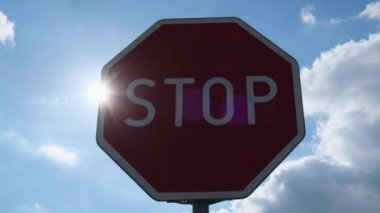 Red stop sign on metal pole on street. Road attention sign on cloudy background. Outdoors