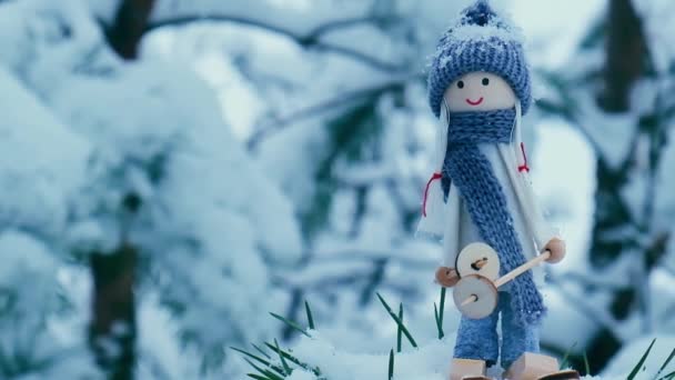 スカーフと編んだ帽子スキーのエンジェルノーム雪の多いモミの枝で雪の風景の中にスキーでエルフのおもちゃ雪の降る天気予報新年とメリークリスマスの背景 スキー冬のリゾート — ストック動画