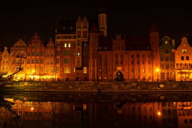 Geceleri Gdansk 'ta eski bir kasaba. Alacakaranlıktaki Moltawa Nehri Kenti 'ndeki Granary Adası yansıması. Alacakaranlıkta antik vinç. Gdansk Polonya 'yı ziyaret edin. Turist eğlencesi