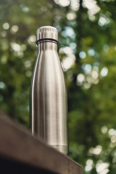 Water bottle. Reusable steel thermo water bottle on wooden bench isometric concept. Sustainable lifestyle. Plastic free zero waste free living. Go green Environment protection. Health-conscious. Steel