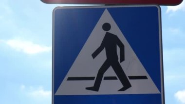 Bisikletçi ve yaya yolu paylaşım tabelası. Yol tabelası yayalar ve bisikletler mavi gökyüzünün arka planında karşıdan karşıya geçebilirler.