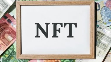 4k, NFT ödenemeyen sembol metnini yakınlaştır. Kağıt üzerinde NFT 'nin karşılanamayan simgesi olan kavramsal kelimeler. Avro faturalarının geçmişi. Zincirleme varlık şifreleme sanatı, dijital sanat, yeni tip şifreleme parası