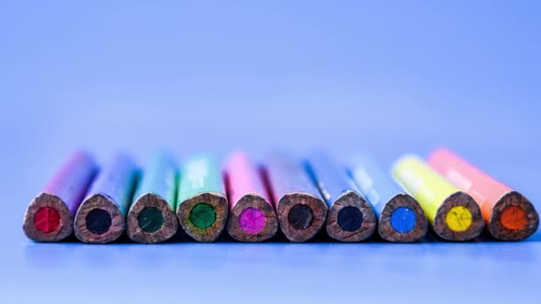 4Kズームアウトクレヨン色の鉛筆の背景 青い背景の色鉛筆 閉めろ 行に配置されたカラフルな様々な鉛筆のトップビュー — ストック動画