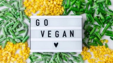 Işıkkutusunu 4 km yakınlaştır. Go VEGAN yazısıyla. Donmuş sebzeler. Sarı mısır, yeşil fasulye. Kış için yiyecekleri toplayın. Boşluğu kopyala