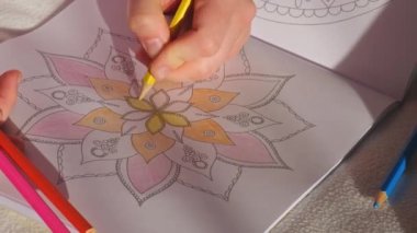 Stres önleyici sayfayı boyayan kadın. 4K kadın el boyaması mandala. Stresle savaşmak için kadın mandalaları boyuyor. Rahatlama hobisi zihinsel refah ve sanat terapisi. Kadın eskiz çiziyor, meditasyon süreci...