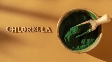 4k yakınlaştır mavi-yeşil algleri CHLORELLA mesajı ile ve bambu eko kasesinde spirulina tozu, vegan, vejetaryen ya da bitki temelli diyet multivitaminleri B12, kaşık içinde süper toz