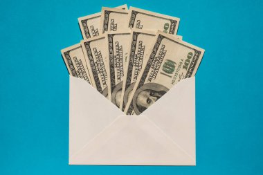 Bir dolarlık banknot, mavi arka plan fotokopi alanındaki zarfta tasarruf ediyor. Tüketim ve ekonomi para topluyor. Bahşiş. İş, finans, tasarruf, bankacılık ve insan konsepti. Ekstra para, pasif