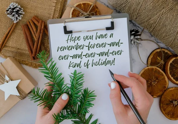 Hope you have a remember-forever-and-ever-and-ever-and-ever kind of holiday Inspiration joke quote phrase Woman making Box with New Years gifts, wrapped in craft paper and decorated with fir branch