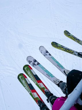 Bukovel Ukrayna - Şubat 2022 Kayak kaldırma seti. Sırıkla profesyonel kayak yapan bir grup arkadaş kış sporları açık hava aktiviteleri. Kış dağ manzarası kayak ekipmanlarını öne yerleştirdi