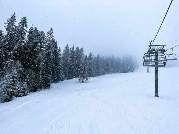 Ski Lift snowy mountain winter forest with chair lift At The Ski Resort in winter. Snowy weather Ski holidays Winter sport and outdoor activities Outdoor tourism skiing snowboarding