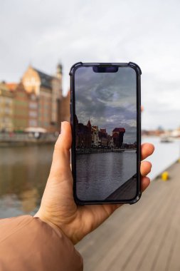 Gezgin, Gdansk 'taki Eski Zuraw Kasabası' nın fotoğrafını çekiyor. Moltawa Nehri 'ndeki Granary Adası yansıması. Gdansk Polonya 'yı ziyaret edin. Birlikte turistik eğlence blogcusu