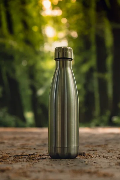 Water bottle. Reusable steel thermo water bottle on green grass. Sustainable lifestyle. Plastic free zero waste free living. Go green Environment protection. Health-conscious. Steel thermo water