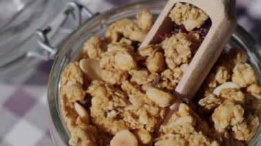 Eko cam kavanozunda fındık ve çekirdekli ev yapımı granola. Kahvaltıda sağlıklı atıştırmalıklar. Granola, yulaf ezmesi, kuru üzüm, bal, yaban mersini, keten, badem, macadamia, kaju, taze pişmiş. 