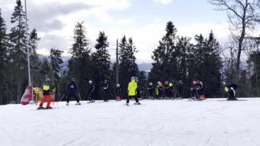 Bukovel Ukraine - February 2022 Children Skier learning skiing downhill in winter resort mountains. Ski area. Skiers and snowboarders riding down the hill. Skiers and lifts in Carpathians alpine ski