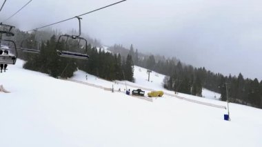 Bukovel Ukrayna - Şubat 2022 Kayak Kaldırma Dağlık Kış Ormanı 'na giden insanlar kış mevsiminde Kayak Tatil Köyü' nde sandalyelerini kaldırıyorlar. Karlı hava Tatilleri Kış sporları ve açık hava aktiviteleri