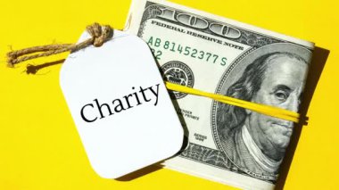 4k yakınlaştır kağıt nota, dolar banknotları etrafında siyah harflerle CHARITY yaz. Para, iş, finans, yatırım, tasarruf. Nakit para. Zenginlik ve refah finansmanı iş bütçesi