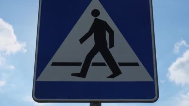 Bulutlu gökyüzünde yaya geçidinin dikey işareti, yaya geçidi. Dikkat dikkat. Açık havada.