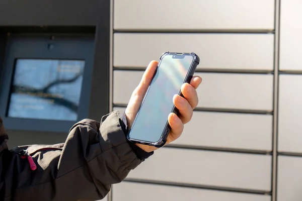 Female Hand Holding Mobile Phone Next Parcel Locker Collecting Parcel — Stock Photo, Image