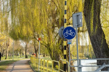 Parktaki boş bisiklet yolu. Konforlu parkta bisiklet yolu. Gölün yanındaki bisiklet için boş bisiklet yolu. Yol tabelası. Açık hava konseptinde eğlence. Pruszcz Gdanski Polonya 'da aktif zaman sporu