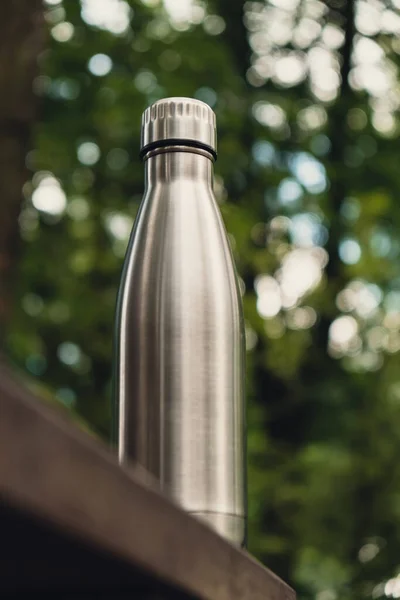 Water bottle. Reusable steel thermo water bottle on wooden bench isometric concept. Sustainable lifestyle. Plastic free zero waste free living. Go green Environment protection. Health-conscious. Steel