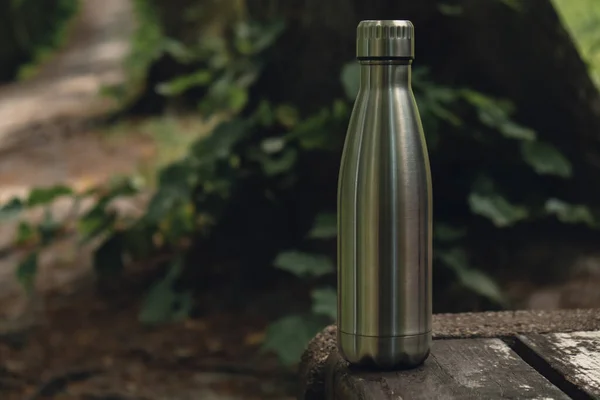 Water bottle. Reusable steel thermo water bottle on wooden bench. Sustainable lifestyle. Plastic free zero waste free living. Go green Environment protection. Health-conscious. Steel thermo water