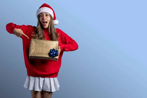 Junge Lateinerin in Weihnachtskleidung mit einem Geschenk in der Hand und Platz für Text — Stockfoto
