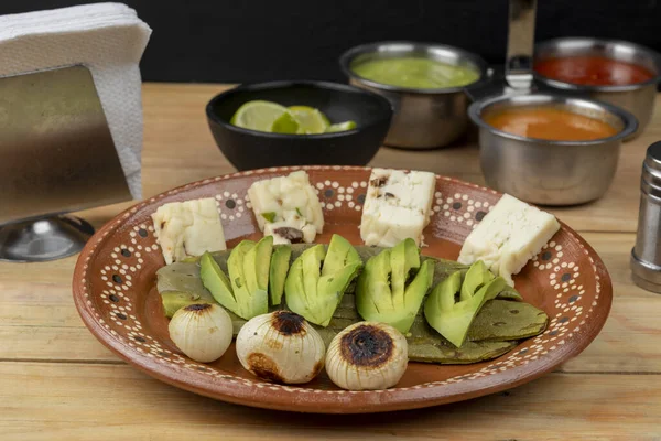 Meksika yemeği. Avokado siparişi, nopal ve soğanlı. Ahşap bir masada, toprak kapta servis ediliyor. — Stok fotoğraf