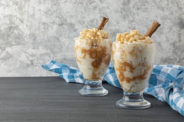 İki bardak sütlaçlı tatlı ve mavi masa örtüsü.