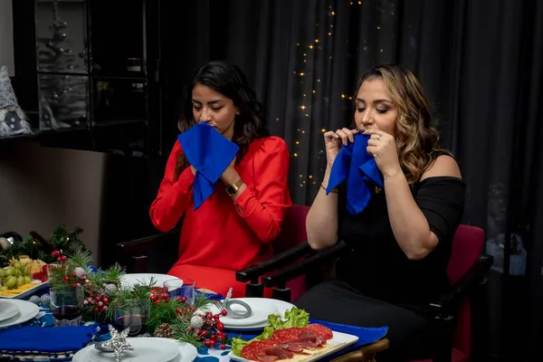 Zwei Frauen wischen sich beim Weihnachtsessen mit einer Serviette den Mund ab — Stockfoto
