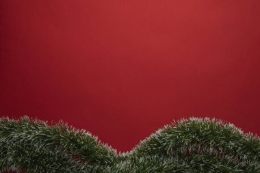 Altında yeşil çalılar olan kırmızı noel arkaplanı, metin için alanı olan