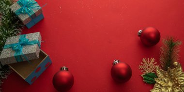 Hediye kutuları, küreleri ve kırmızı arkaplanı olan Noel arkaplanı