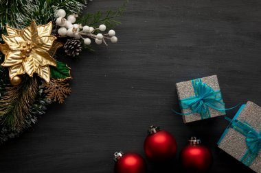 Kırmızı küreler, hediyeler ve iyi geceler ile siyah bir arka planda Noel süslemesi