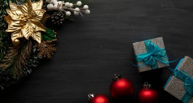 Kırmızı küreler, hediyeler ve iyi geceler ile siyah bir arka planda Noel süslemesi