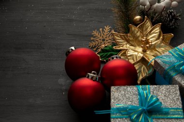 Noel süslemeli siyah ahşap küreler hediyeler ve altın çiçeklerle