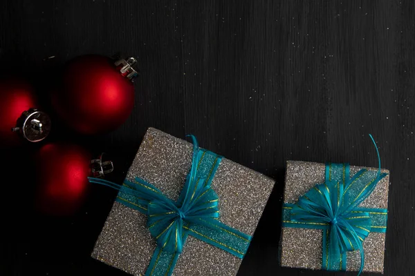 Weihnachten Hintergrund mit roten Kugeln und silbernen Geschenken mit blauer Schleife und Platz für Text — Stockfoto