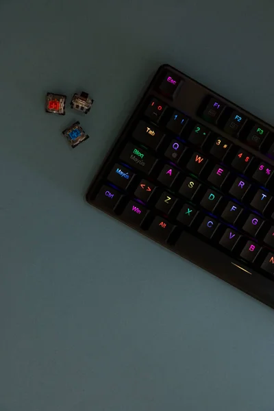 Вертикальне зображення геймерської клавіатури на сірій основі з вимикачами збоку — стокове фото