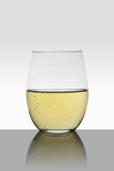 Kristályüveg fehér borral és fehér háttérrel — Stock Fotó